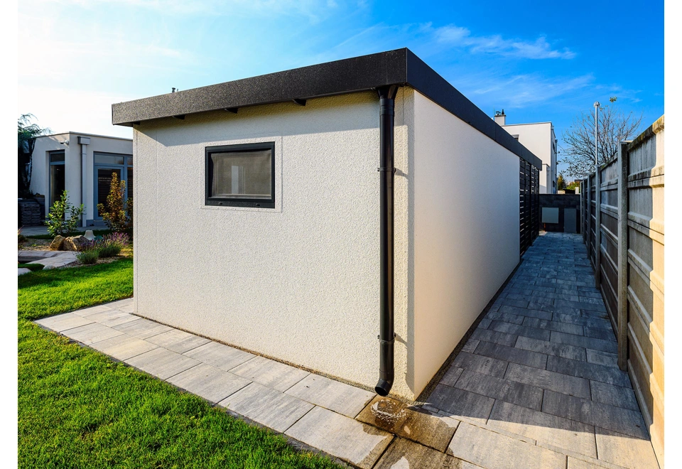 Detail rohu montované garáže 5,8 x 6 m s oknem a okapem, bílá designová omítka