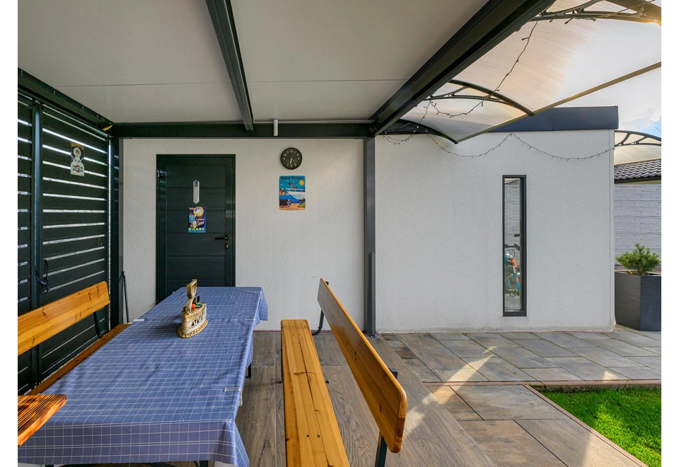 Boční stěna montované garáže 3 x 6 m s bílou omítkou, světlíkem a zateplenými jednokřídlými dveřmi