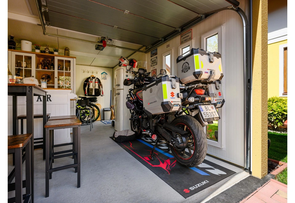 Interiér montované garáže 3 x 6 m se třemi světlíky, otevřenými vraty ke stropu, bílé stěny a zateplená střecha