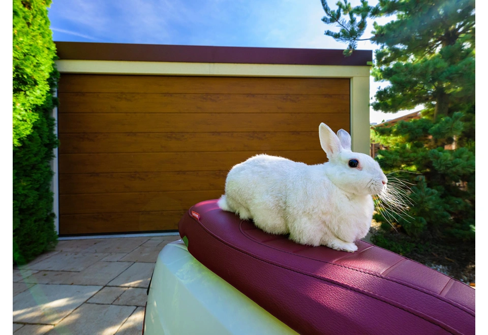 Sekční garážová vrata v hnědé montované garáže 4,5 x 7 m se žluto-pískovou fasádou.