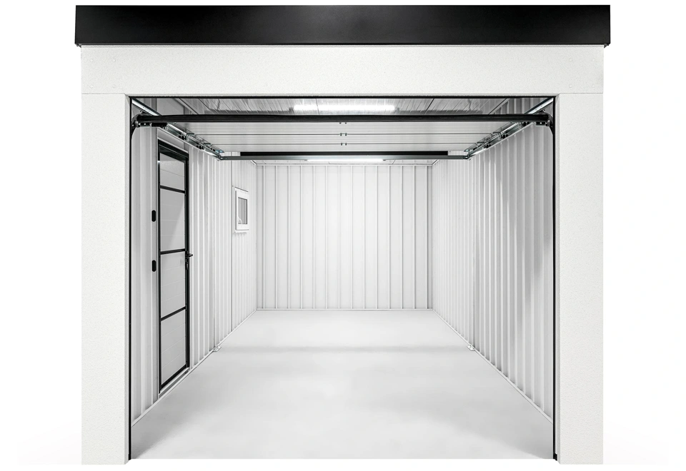 Interiér montované garáže 3 x 6 m s bílými stěnami a prázdným prostorem, jednokřídlé zateplené dveře a okno.