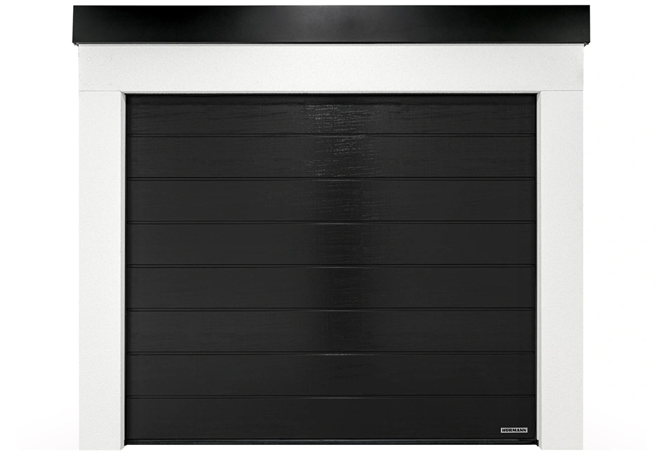 Montovaná garáž 3 x 5 m s bílou omítkou, sekčními vraty a atikou v černé barvě.