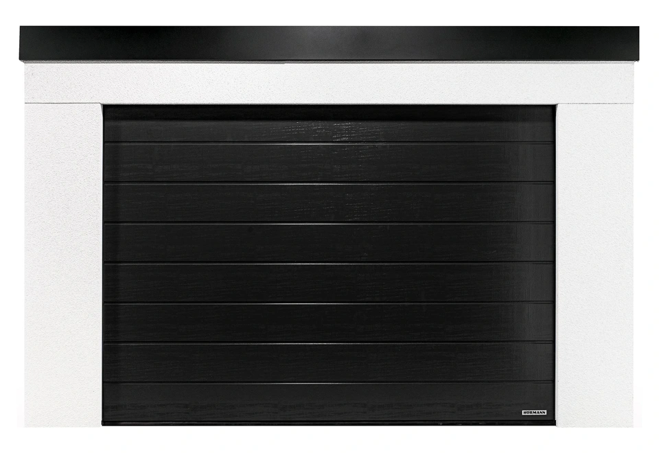 Montovaná garáž 4 x 7 m s bílou omítkou, černými sekčními vraty a atikou v černé barvě.