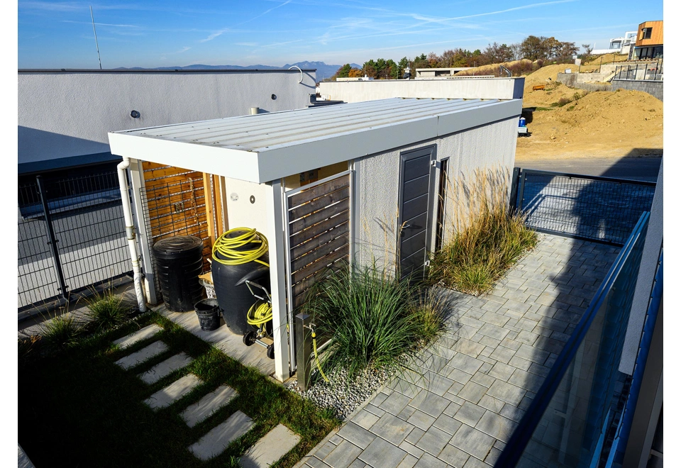 Garáž 2,5 x 5 m s vraty, světlíkem a přístřeškem na levé straně.