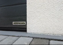 Detail designové bílé omítky a sekčních garážových vrat.