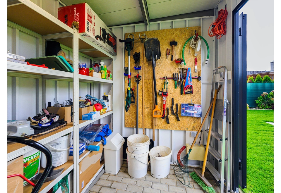 Interiér zahradního domku 3,5 x 2 m s regály, bílými stěnami a zateplenou střechou.