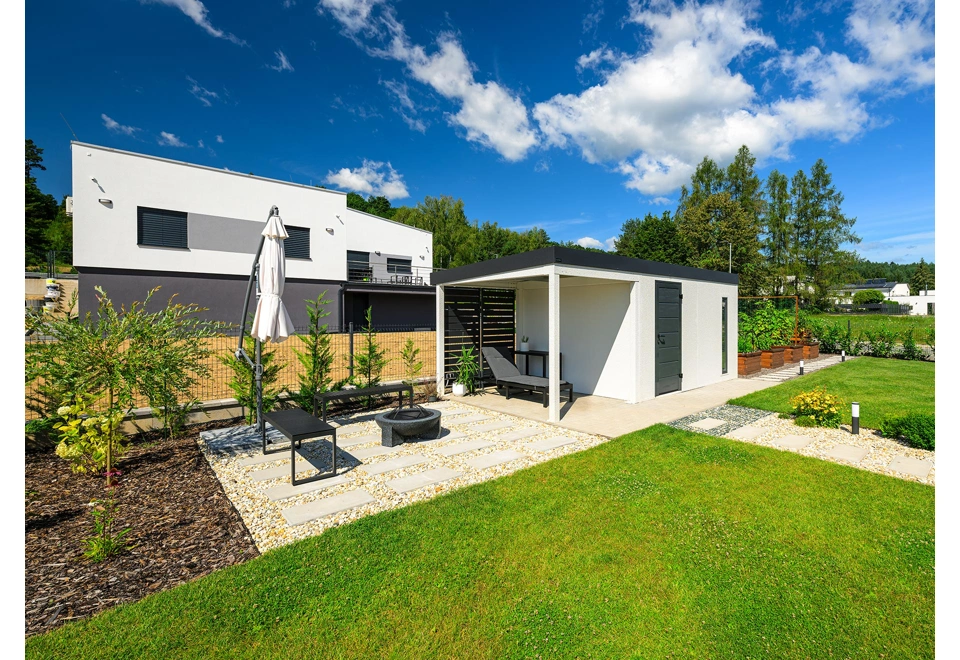 Přístřešek se zástěnou zahradního domku 4 x 3 m s dveřmi a světlíkem, bílá omítka a antracitová atika se zateplenou střechou.