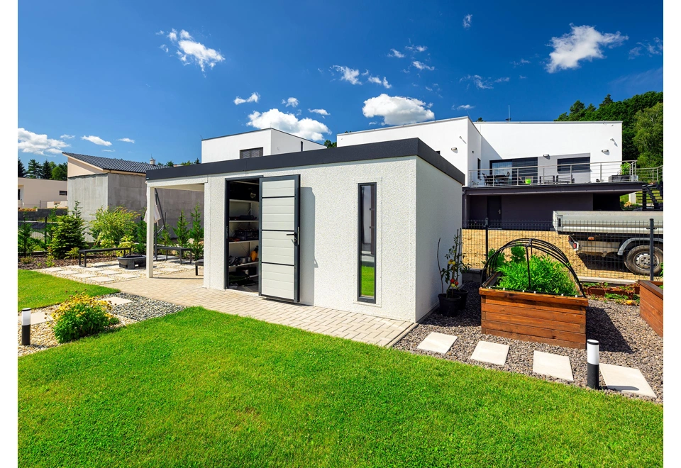 Zahradní domek 4 x 3 m s levým přístřeškem, světlíkem, otevřenými zateplenými dveřmi, bílou omítkou a antracitovými doplňky.