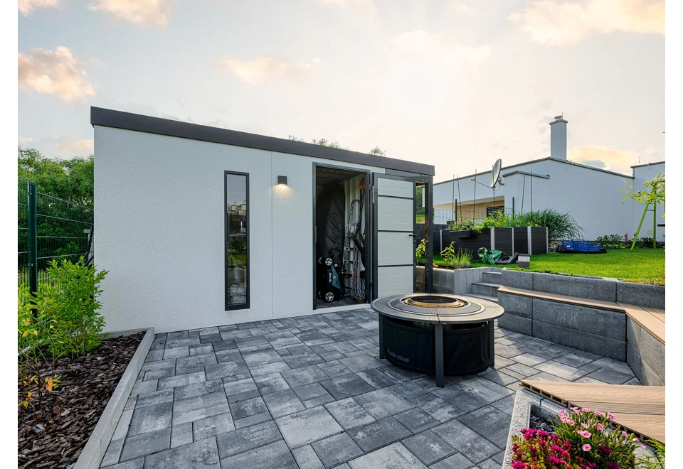 Otevřené zateplené jednokřídlé dveře zahradní domku 3 x 2 m se světlíkem, bílou omítkou, antracitovými doplňky a zateplenou střechou.