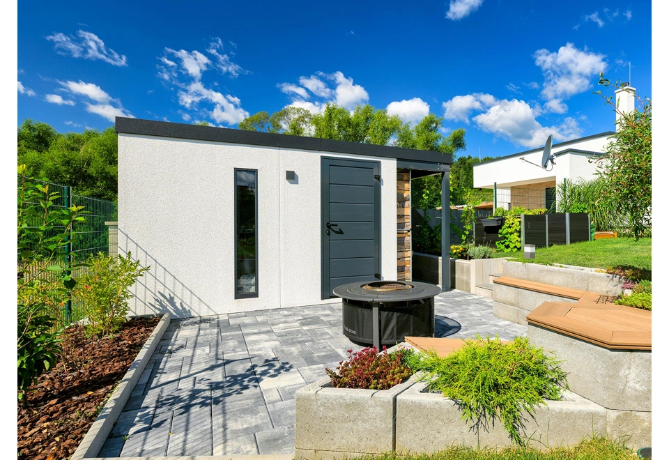 Detail stěny montovaného zahradního domku 3 x 2 m se světlíkem, dveřmi a pravým přístřeškem, bílá omítka a antracitové doplňky.