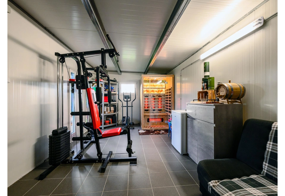 Interiér zahradního domku 5,8 x 3 m s oknem a zateplenou střechou, domácí posilovna a infrasauna