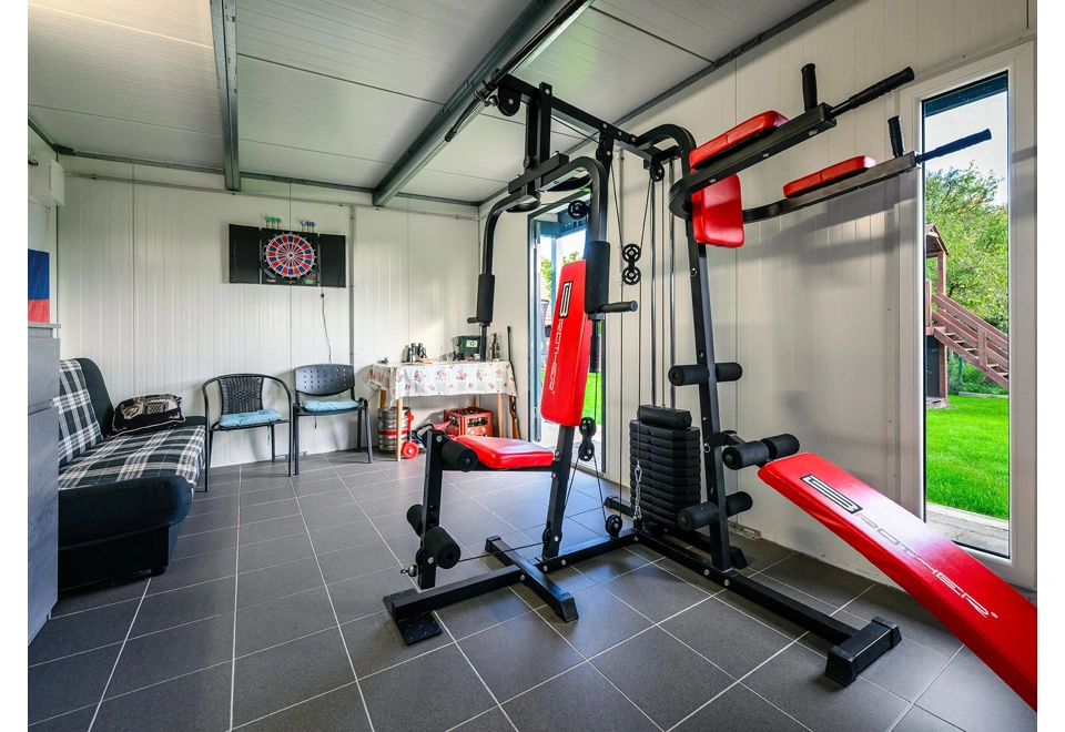 Domácí posilovna zahradního domku 5,8 x 3 m s bílými stěnami, světlíkem a jednokřídlými dveřmi