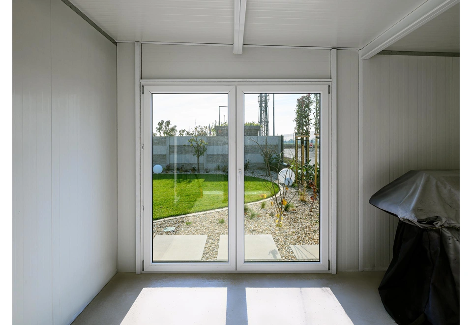 Prosklené dvojité dveře interiéru zahradního montovaného domku 4 x 4 m, bílé stěny, zateplená střecha