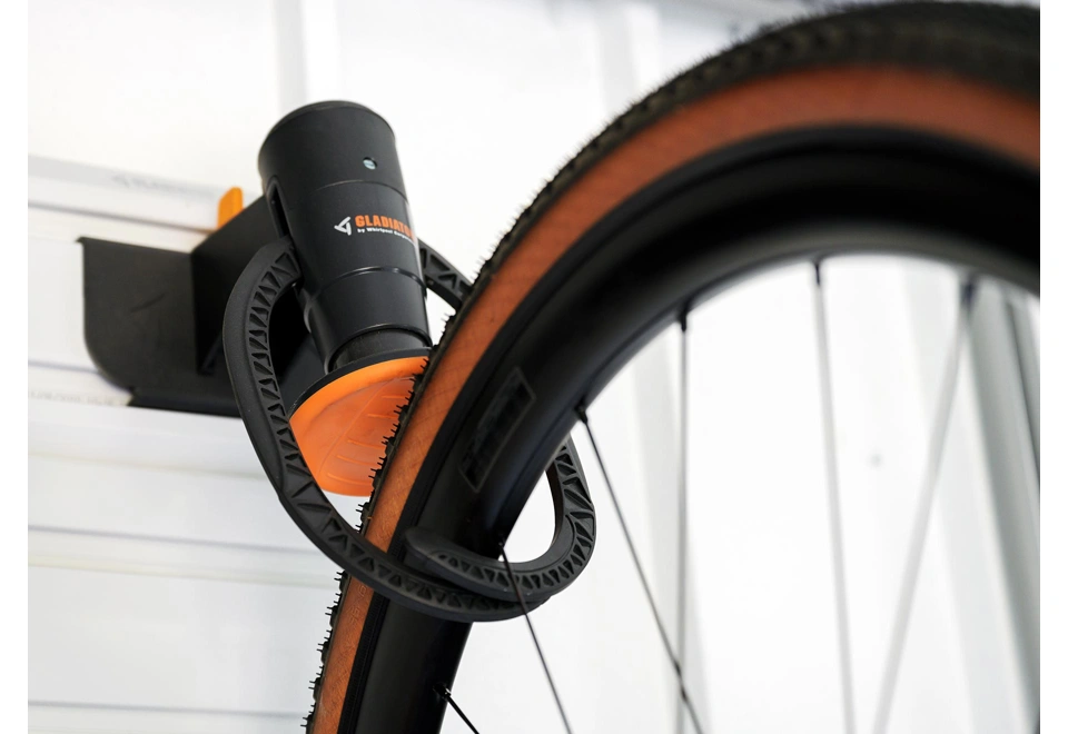 Detail závěsného háku na cyklistické kolo na bílé stěně zahradního domku 4 x 3,5 m