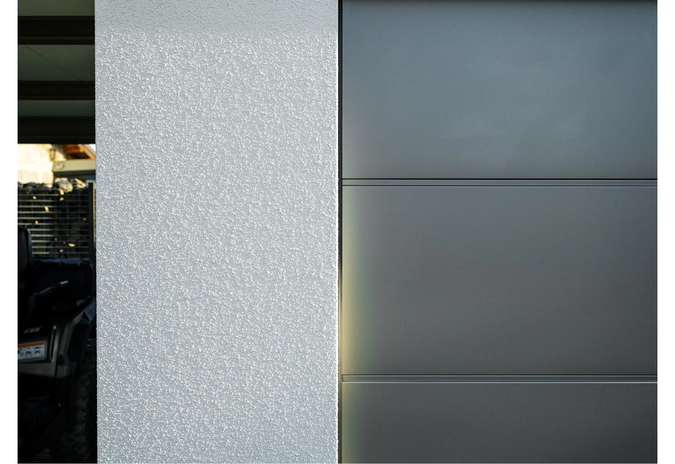 Detail designové omítky a garážové brány v antracitu zahradního domku 4 x 3,5 m