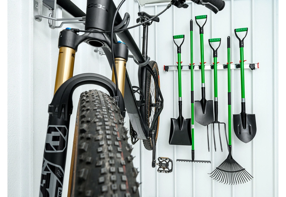 Detail držáku na kolo a nářadí zahradního domku 3 x 2 m s bílými stěnami.