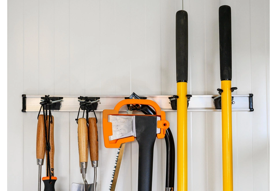 Držák na nářadí v zahradním domku  4 x 3 m s bílými stěnami.