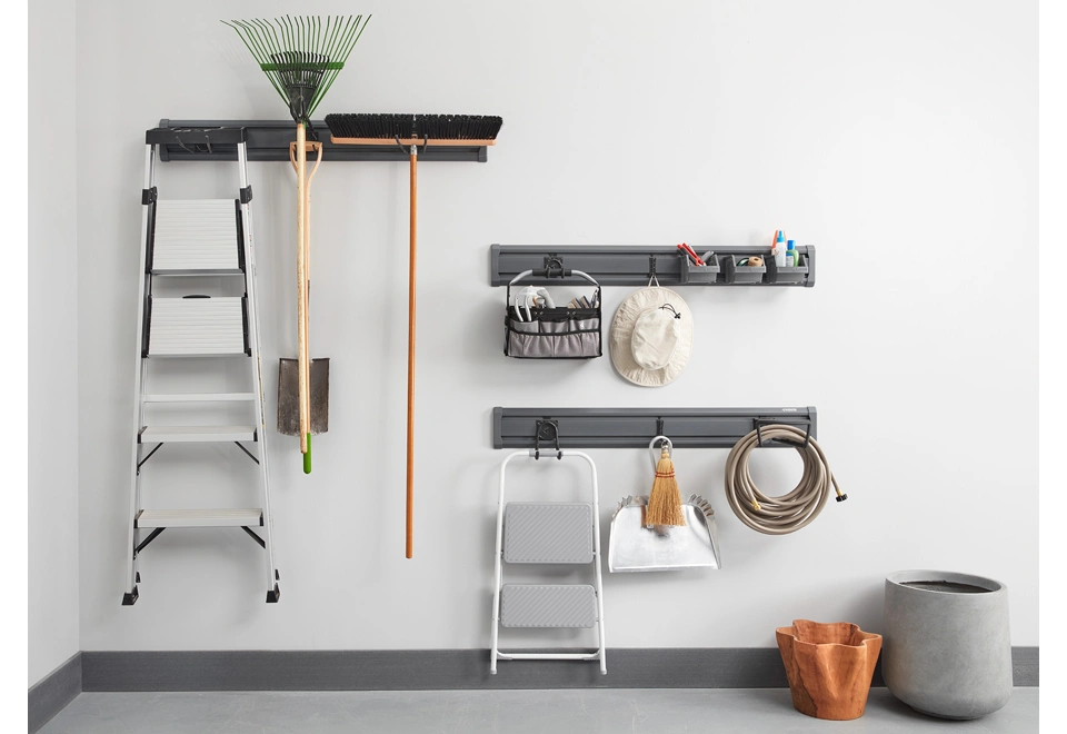 Tři nástěnné kolejnice s háčky a košíky na nářadí.