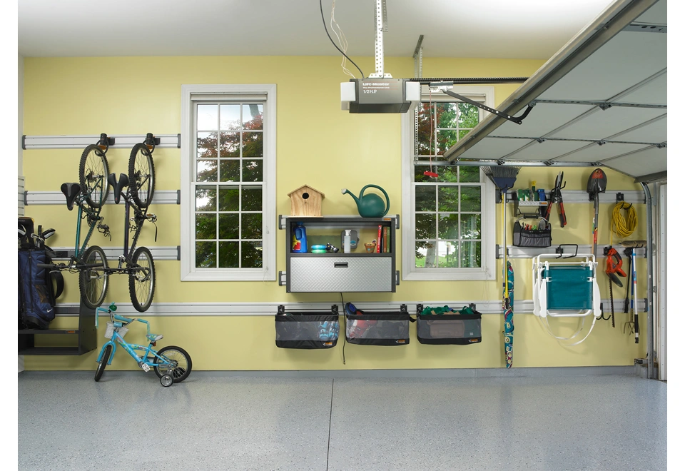 Ocelová skříň s jednou otevřenou a jednou uzavřenou policí zavěšená na dvou nástěnných kolejnicích.