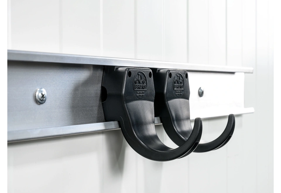 Nástěnné háčky na nářadí na bílé stěně zahradního domku GARDEON®.