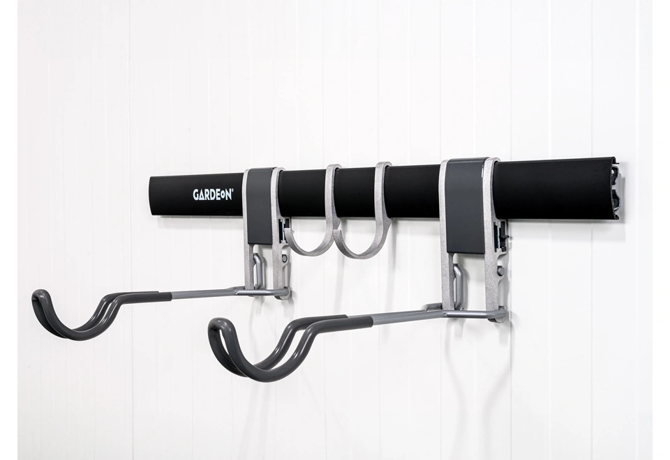 Černý závěsný systém na cyklistické kolo na bílé stěně zahradního domku GARDEON®.